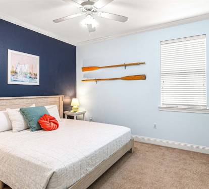 A king bed with coastal vibes and a pop of color to match the view