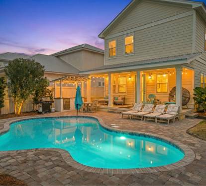 Heated pool, patio, and backyard at dusk—perfect for evening swims and outdoor entertaining.