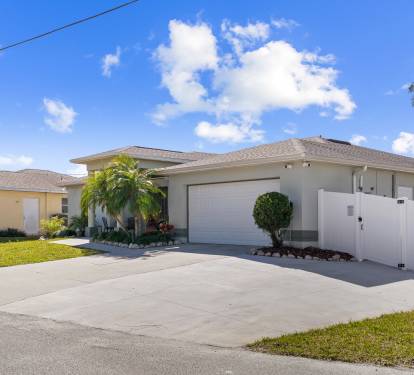 Charming facade, lush landscaping, and spacious driveway.