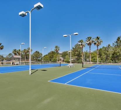 Lighted tennis courts ready for daytime matches or evening play.
