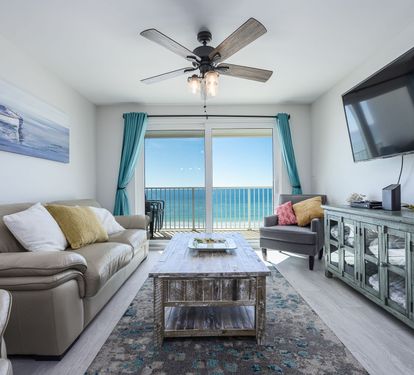 Living Room with Breathtaking Views Relax in this stylish living area, featuring plush seating, coastal decor, and a large flat-screen TV. The sliding glass doors lead to your private balcony,