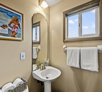 The luxurious yet functional bathroom is spacious, decorated with gorgeous materials, stylish accent details and filled with light.