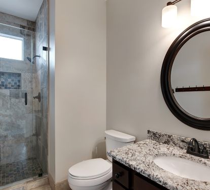 Bathroom with tiled walk-in shower and granite vanity
