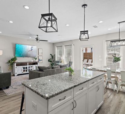 The open-concept living area includes a kitchen island, dining space, and kitchen.