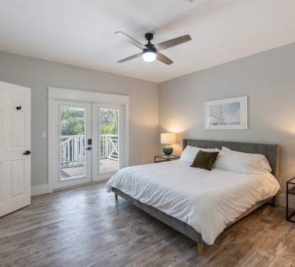Primary bedroom with king bed. The doors lead to outdoor deck and the backyard 