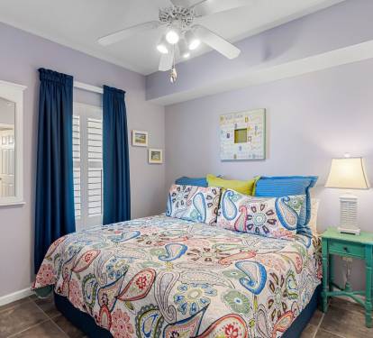 Guest bedroom w/ two beds, cheerful colors & a fun coastal vibe.