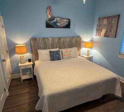 First Floor Bedroom 1 offers a peaceful coastal escape with soft blue tones, warm lighting, and soothing comfort.