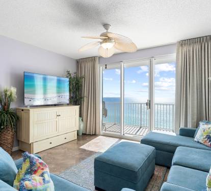 Inviting living room w/ plush sectional, TV & sliding doors opening to ocean views and fresh coastal breezes.