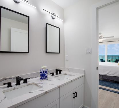 "Indulge in the master bathroom’s spa-like ambiance, complete with a double vanity, modern fixtures, and a sleek glass-enclosed shower/tub combination. ??? #LuxuryLiving #CoastalComfort"