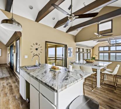 Enjoy dining in this open-concept kitchen featuring granite countertops, an abundance of natural light, and a sleek, modern design.