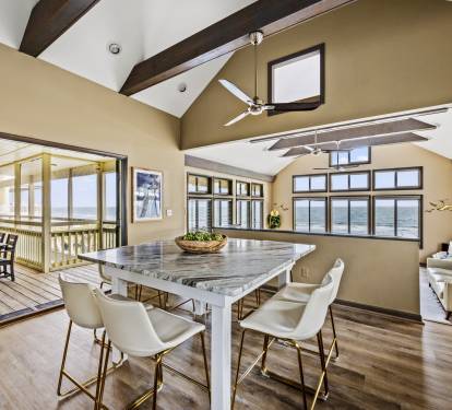 Experience coastal luxury at its finest with this stunning open-concept kitchen and living area. The fully-equipped kitchen boasts gorgeous sea views, while the comfortable seating area provid