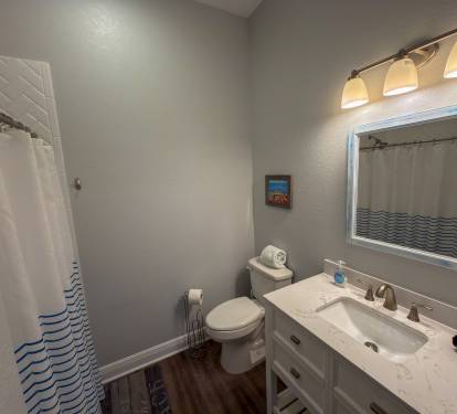 Ensuite Bathroom 2 features a walk-in shower, updated vanity, and subtle seaside décor that complements the home’s beachy atmosphere.