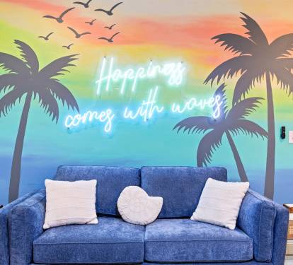 Happiness Comes in Waves — our signature mural sets the tone for the whole trip. You can't be stressed in this room.