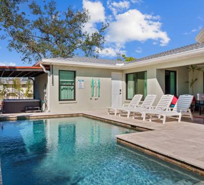 A stunning private pool area. Featuring a sparkling pool, comfortable sun loungers, and lush tropical landscaping, this outdoor oasis is a feast for the senses.