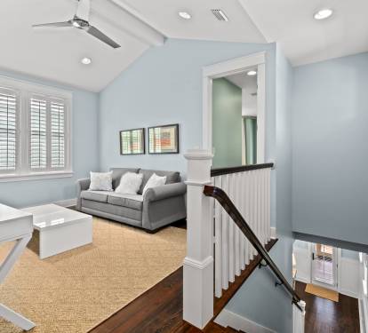 Upstairs loft w/ sofa, desk & airy ceilings—perfect for lounging or quiet time.