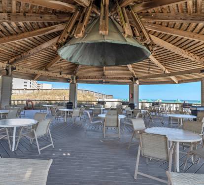 Beachfront pavilion w/ shade and seating near the shoreline.