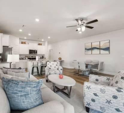 Main living: Kick back on plush couches and enjoy effortless indoor flow to the dining area and full kitchen.