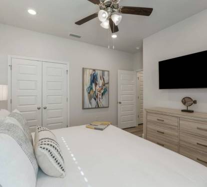 Bedroom 4: MIL Bedroom- Comfortable and airy bedroom with natural light, a ceiling fan, and thoughtful bedside details.