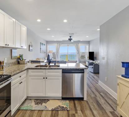 Fully stocked kitchen with view to living room and ocean