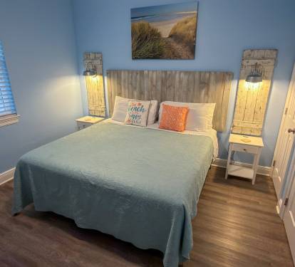 First Floor Bedroom 2 showcases ambient bedside lighting, driftwood-inspired décor, and a cozy King bed for ultimate comfort.