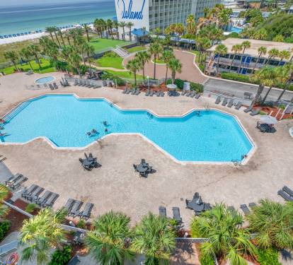 Elevated balcony view overlooking the resort pools and palm trees.