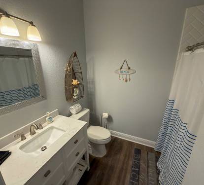 Ensuite Bathroom 1 features a spacious walk-in shower and cheerful nautical accents that reflect the home’s coastal aesthetic.