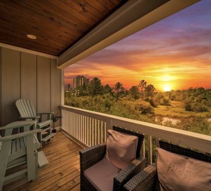 Relax on the tall Adirondack gliders with your favorite night-cap while the sun sets over the serene unobstructed wetland views.  The property joins the Gulf State Park area, so there are no houses directly behind this one.