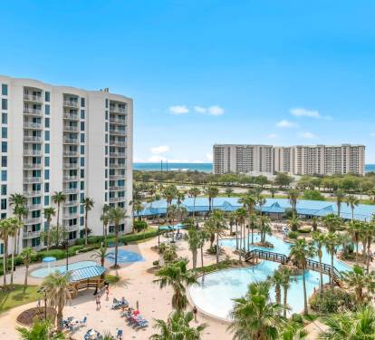 Elevated view over the pool complex & palm-lined grounds, bringing vacation vibes front & center