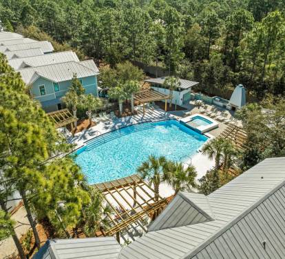 Resort-style pool framed by palms, pergolas & loungers—an inviting spot to cool off on sunny days.