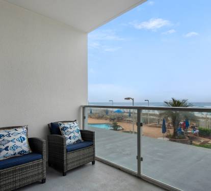 Balcony seating overlooking pool and beach