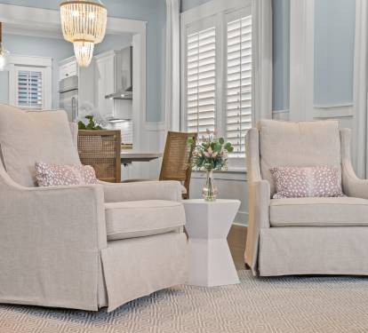 Cozy reading nook w/ plush armchairs, side table & gentle natural light—perfect for relaxing with a book.