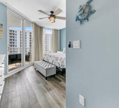 Bright bedroom angle w/ sliding doors leading to the balcony & plenty of natural light