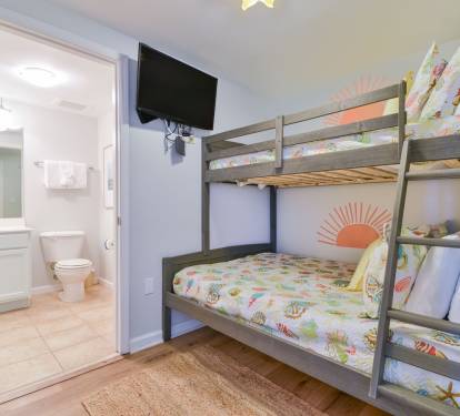 Fun bunk room w/ built-in bunks, playful decor, and easy access to the nearby bathroom.
