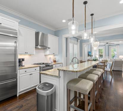 Spacious kitchen w/ granite island, bar seating & pendant lights flowing into the main living area.