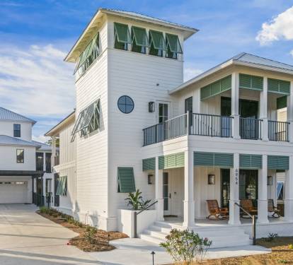 Magnolia Mooring’s front exterior showcases timeless coastal design with crisp white siding, classic Bahama shutters, and double front porches that invite you to slow down and settle in. A generous driveway offers easy parking, with the guest house tu