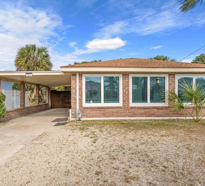 Pull right up to the covered carport of this brick ranch home.  Palm trees frame the entry, picture windows face the front, and the Gulf
is behind you.