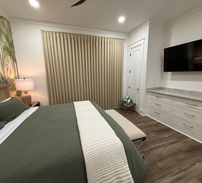 Downstairs master with blackout drapery, 55-inch TV, built-in dresser