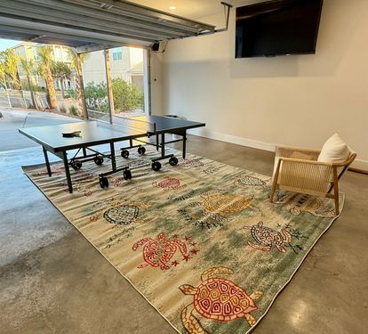 Roll up the garage door, rack up the ping pong table, and let the games run late — this is the room your group will fight over.