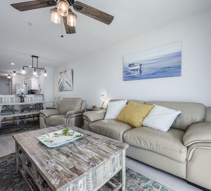 Living Room with Breathtaking Views Relax in this stylish living area, featuring plush seating, coastal decor, and a large flat-screen TV. The sliding glass doors lead to your private balcony,