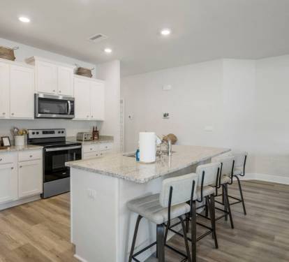 Main Kitchen: Entertain and cook in style with a full kitchen equipped with a breakfast bar and premium appliances.