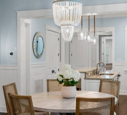 Dining space looking into the kitchen, highlighted by statement lighting & a clean, open layout.