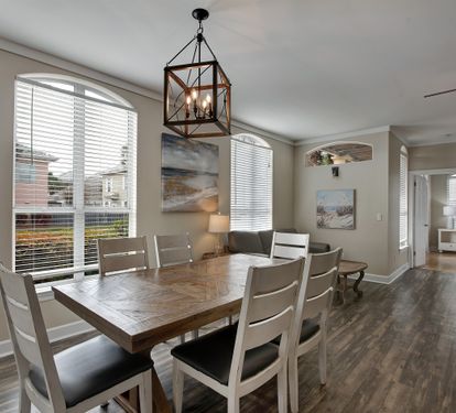Formal dining area with farmhouse-style table and chandelier