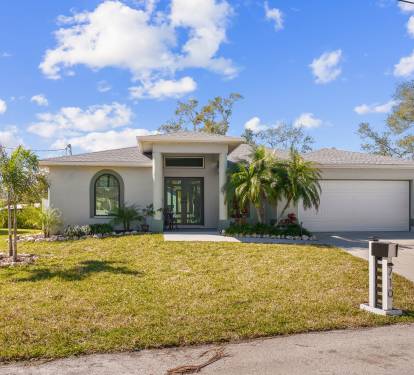 Charming facade, lush landscaping, and spacious driveway.
