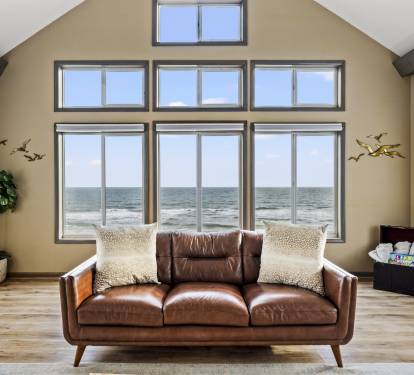 Experience coastal elegance in this room featuring a perfect blend of interior decor, soft textures, warm color tones, and comfortable furnishings, all while enjoying the magnificent ocean vie