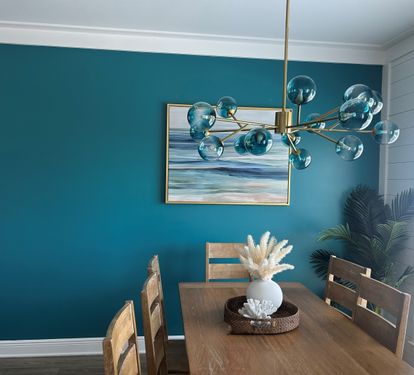 The custom-painted Grand Canal accent wall - a rich Gulf inspired backdrop that sets the tone for your entire stay. Each element, from the brass sputnik chandelier with beautiful teal globes to the coastal seascape, chosen to reflect the colors of the Gul