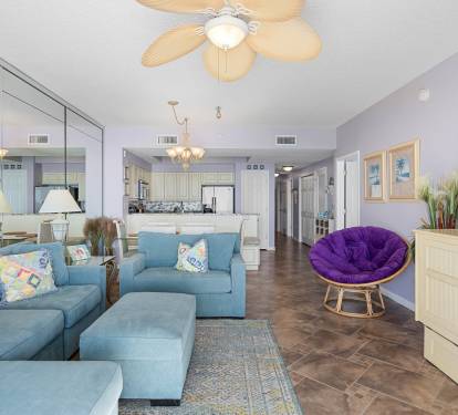 Inviting living room w/ plush sectional, TV & sliding doors opening to ocean views and fresh coastal breezes.