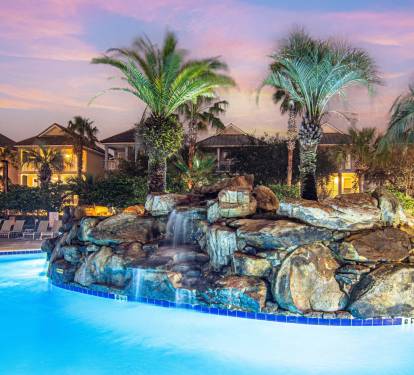 The resort pool lit up at night — pure vacation magic
