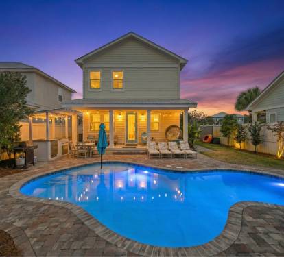Twilight view of the heated private pool and spacious patio area.