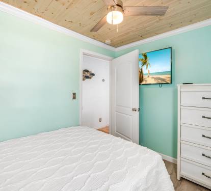 Bedroom upstairs with a queen bed and 50 inch Roku tv.