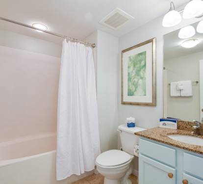 Fresh bathroom w/ tub & shower combo, granite counter, and bright lighting for an easy start to the day.